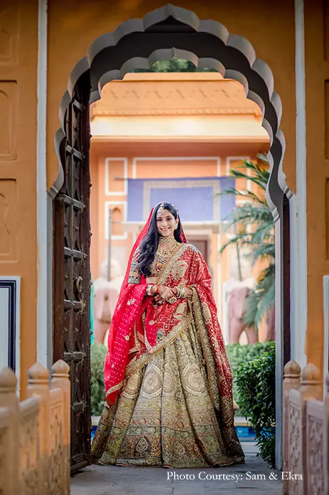 Bride in Gold multi-colored lehenga by Rimple and Harpreet Narula with Red Bandni dupatta and Kundan jewelry