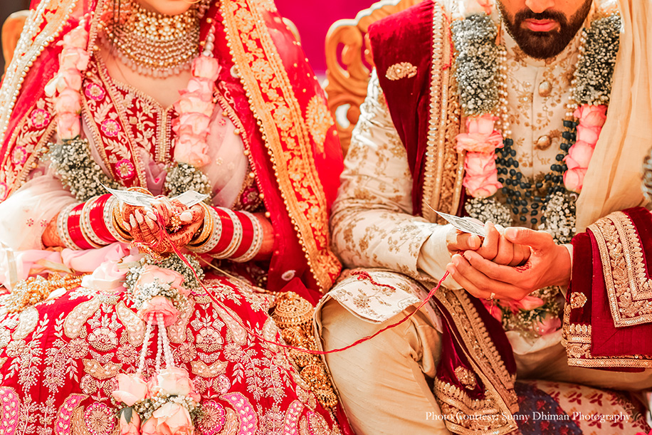 Bride in red lehenga by Mongas and Groom in off-white sherwani by Sabyasachi