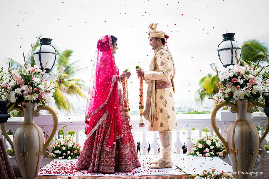 Bride wearing pink lehenga by Anita dongre and groom wearing cream sherwani for the wedding at Taj Falaknuma palace, Hyderabad
