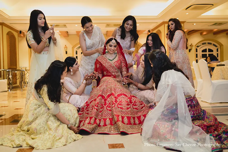 Bride in red Sabyasachi lehenga with her squad