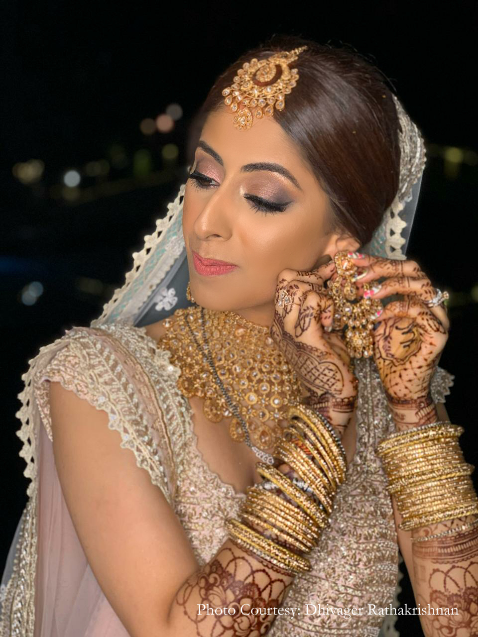Bride wearing Blush lehenga with golden jewelry