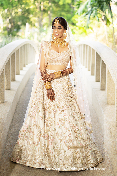 Bride wearing Blush lehenga with golden jewelry