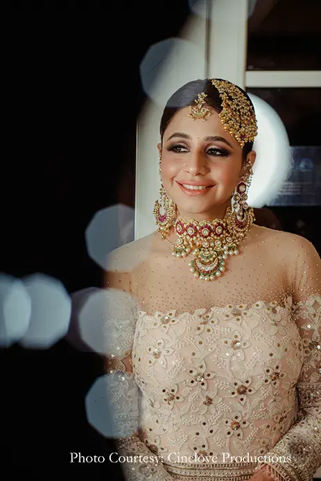bride wearing Nawabi elegance in an off-shoulder embroidered cream lehenga and a Mughal passa for the dhol night