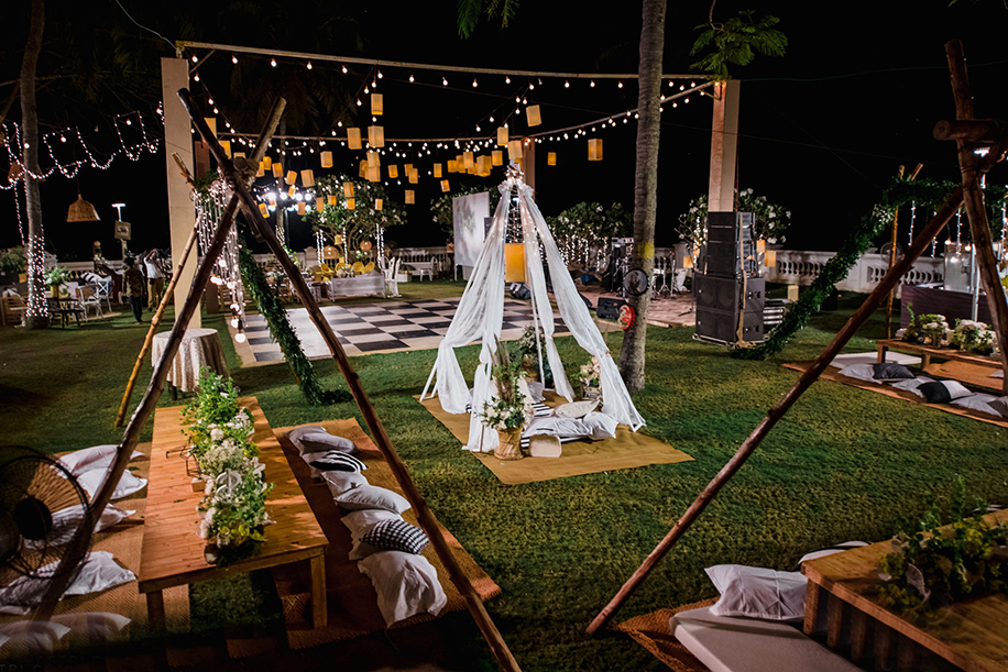 Retro outdoor movie night garden decor, tepees, lamps, rustic boho elements.
