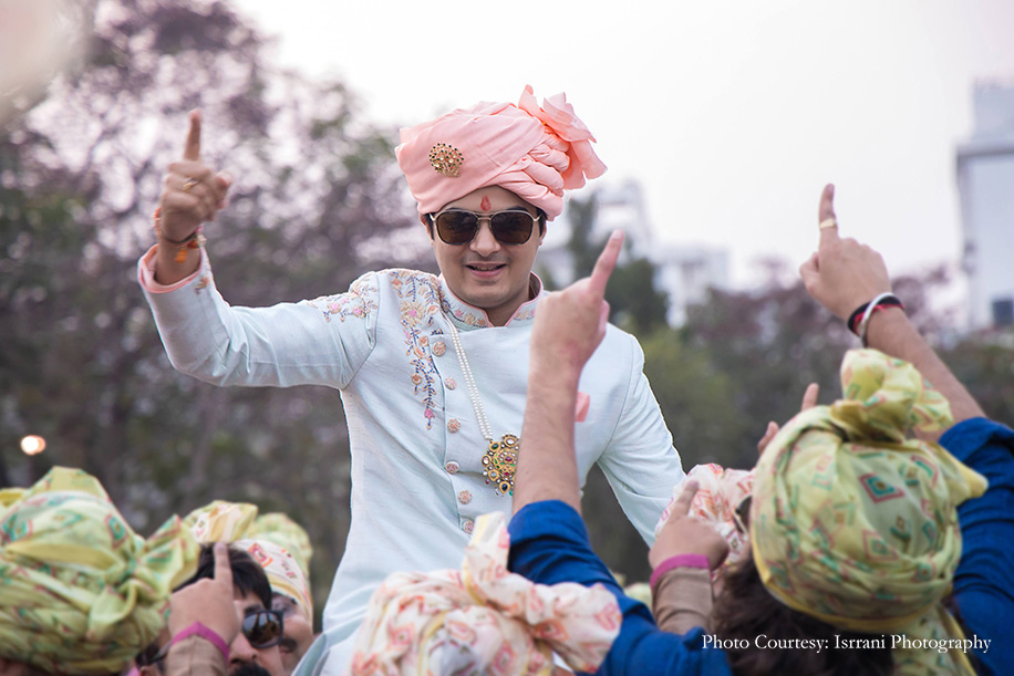 Groom in pastel green bandhgala with pink floral embroidery details at baraat