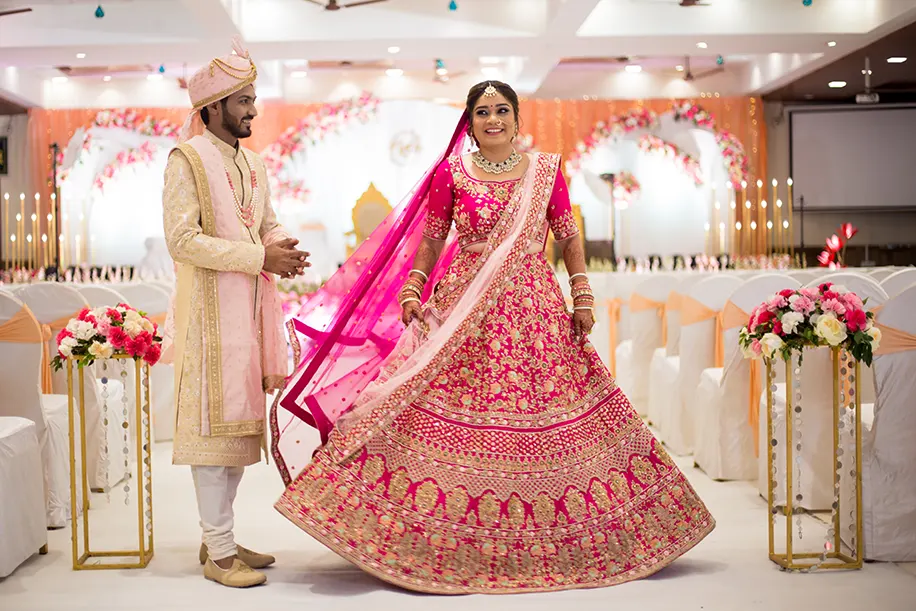 Groom wearing off-white sherwani and bride wearing pink lehenga