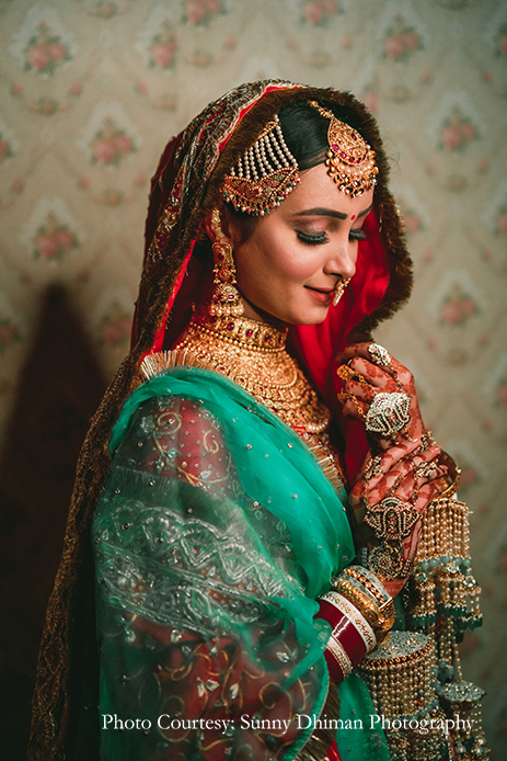 Bride wearing Rajasthani embroidery red and turquoise lehenga with statement jewelry