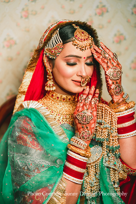 Bride wearing Rajasthani embroidery red and turquoise lehenga with statement jewelry