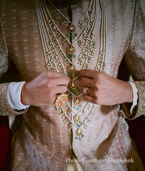 Groom in embroidered and heavily accessorized royal sherwani