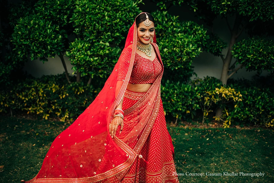 Bride twirling in stunning red wedding lehenga