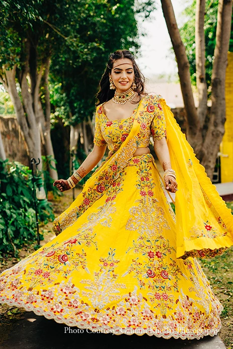 Bride twirling in stunning yellow lehenga 