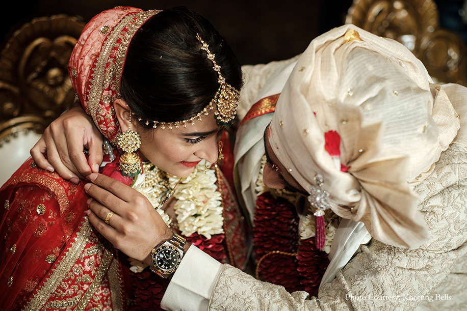 Bride wearing red Sabyasaachi lehenga and groom wearing off-white sherwani by Shantanu and Nikhil Bride wearing red Sabyasaachi lehenga and groom wearing off-white sherwani by Shantanu and Nikhil