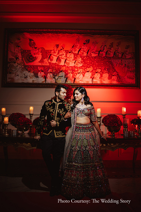 couple matching Outfits for the red roses tied with the sangeet décor
