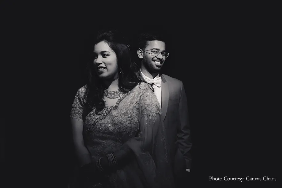 Bride wearing peach lehenga and groom wearing grey tuxedo for the sangeet