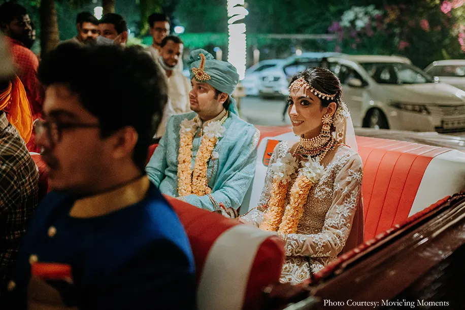 Bride wearing white lehenga and groom wearing mint green sherwani with kundan jewelry and safa for the wedding