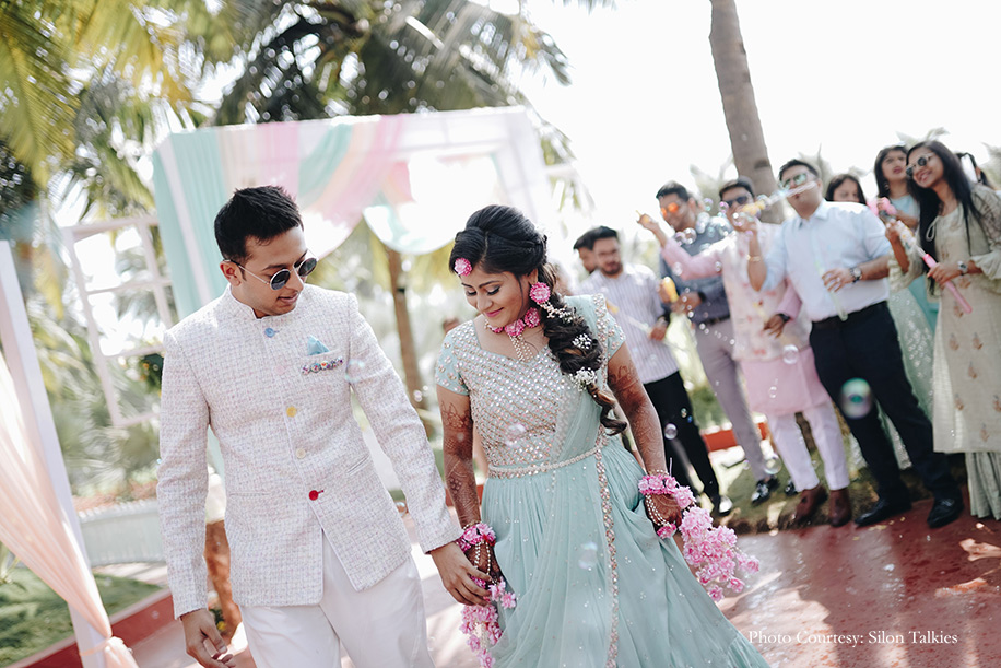 Groom donned a white bandhgala by Just Men while the bride was dressed in a sea green ‘Chamee and Palak’ lehenga with floral jewelry from ‘Floral by Shayoni’ with white and yellow floral decor for the mehendi function