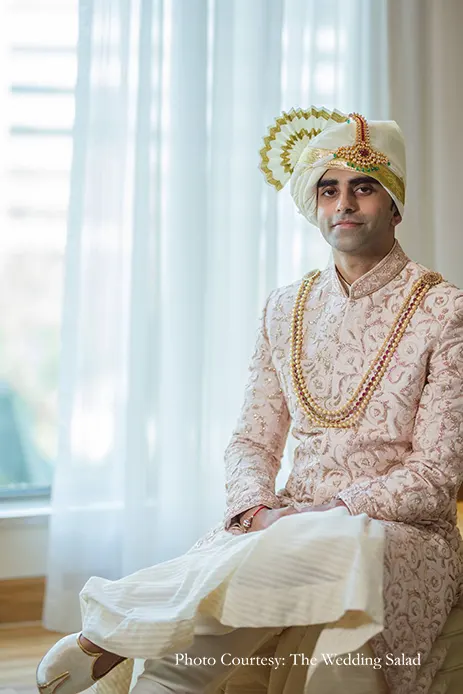 Groom in ivory sherwani with intricate embroidery in blush pink