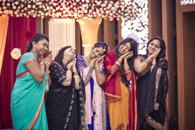 Friends of the brides pulling off a funny pose at her wedding